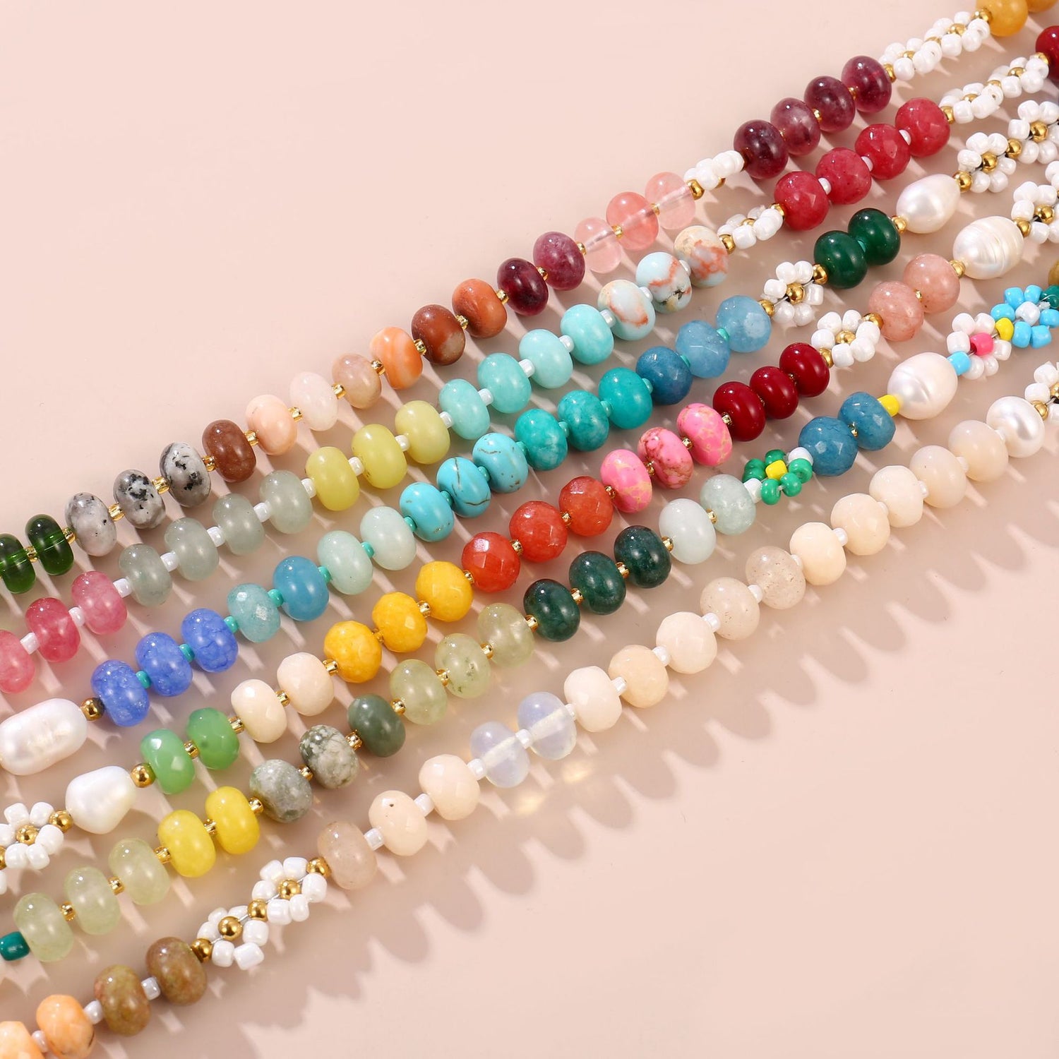 Close detail of natural stone rondelle beads, freshwater pearl and glass daisy on the handmade necklace