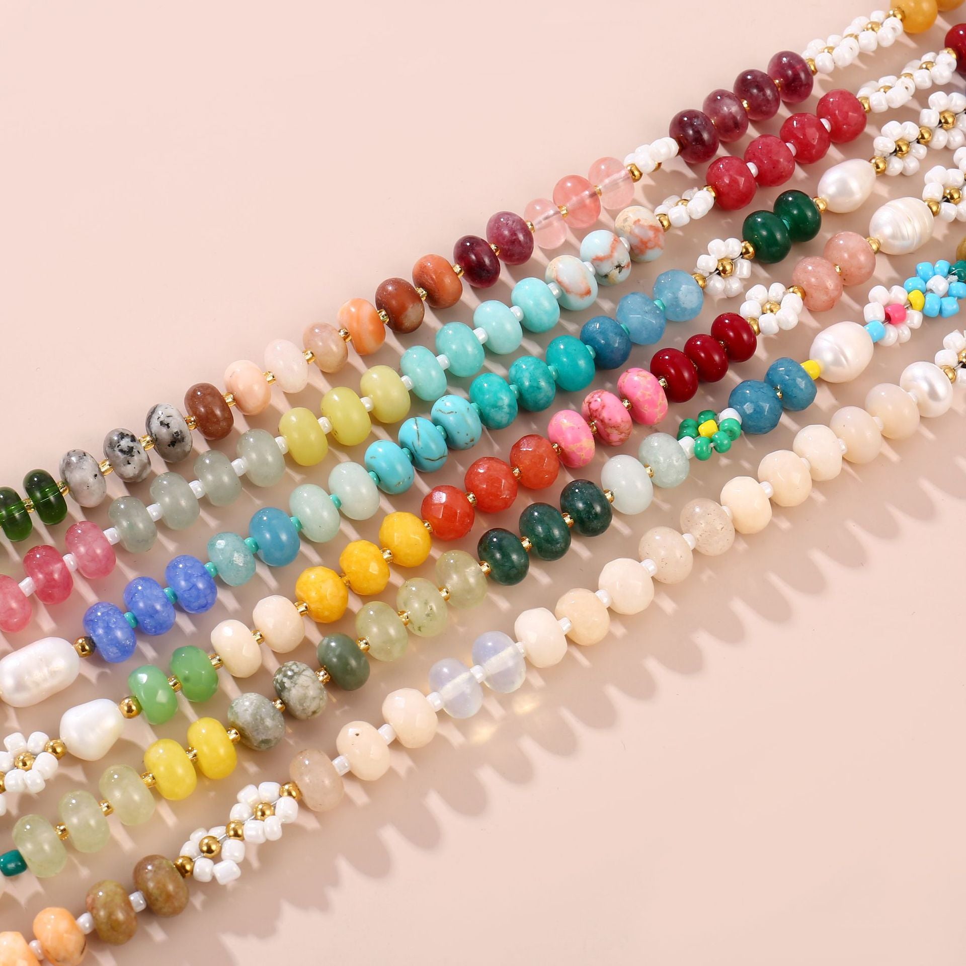 Close detail of natural stone rondelle beads, freshwater pearl and glass daisy on the handmade necklace