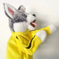 Close view of the grey and white plush dog head and yellow velvet sleeve with black side stripe