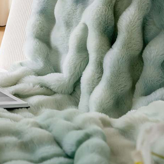 Close view of the ruched bubble texture on a plush polyester coral fleece throw