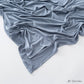 Solid tone modal cotton headscarf wrap laid in soft folds showing the fine jersey knit surface