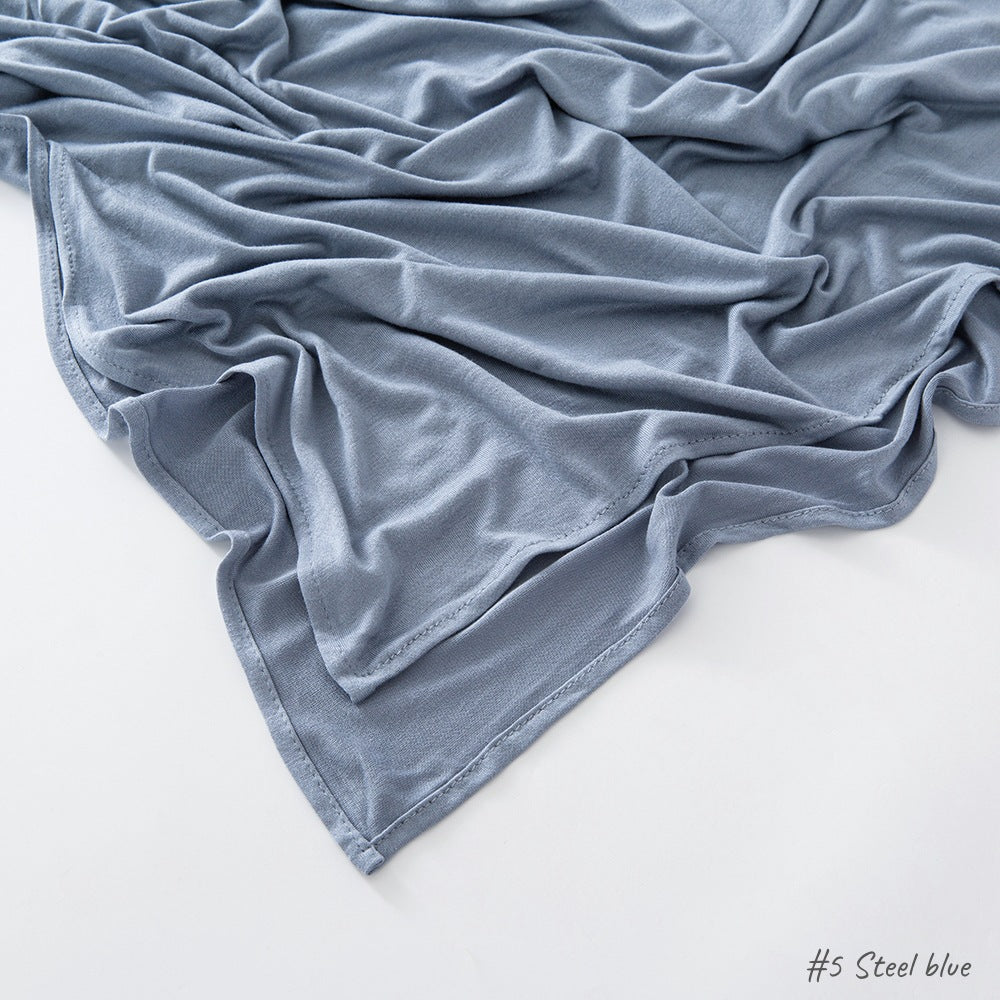 Solid tone modal cotton headscarf wrap laid in soft folds showing the fine jersey knit surface