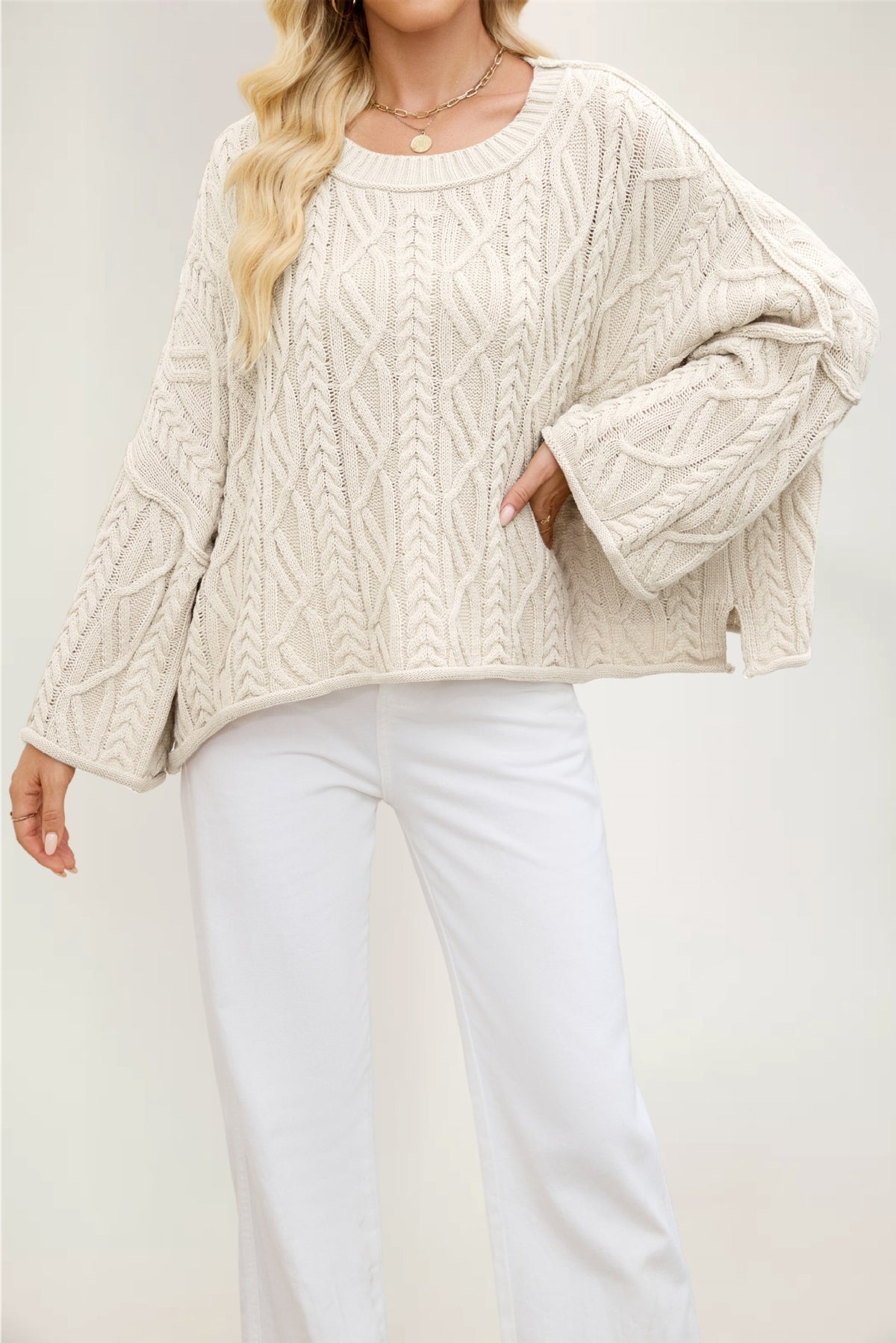 Cable knit pullover with wide flared sleeves and a short side slit at the boxy hem