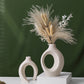 Nesting ceramic vase pair on a table with dried pampas grass