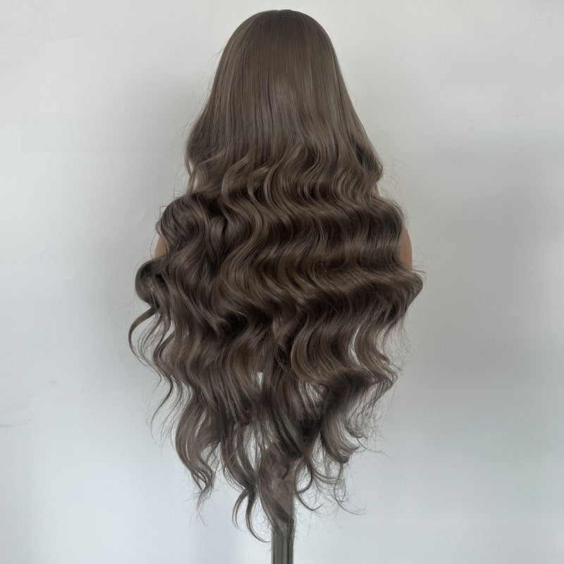 Back view of a long wavy gray brown synthetic wig on a mannequin against a light wall