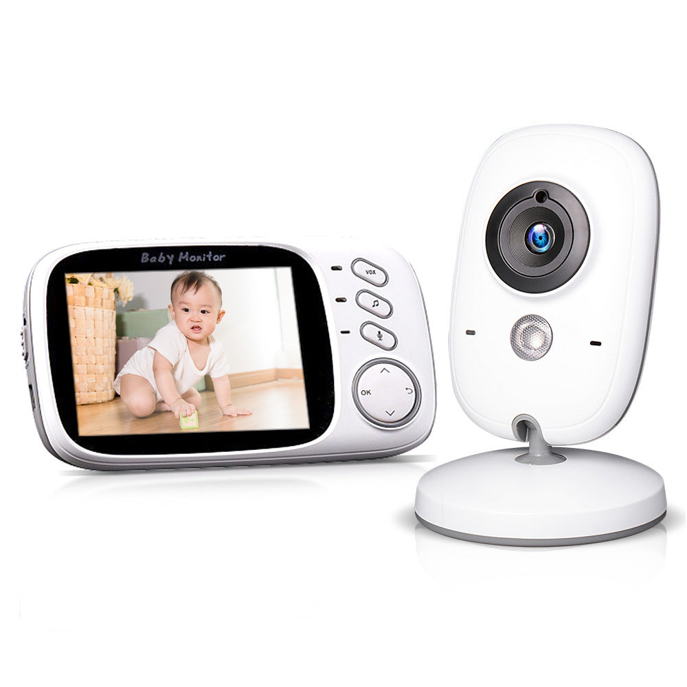 White baby monitor camera on a round stand beside a handheld screen showing a crawling baby