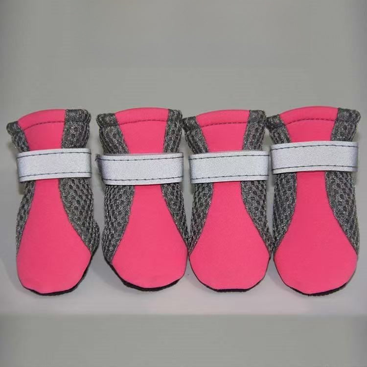 Mesh dog shoe held to show the soft flexible rubber sole and grip tread