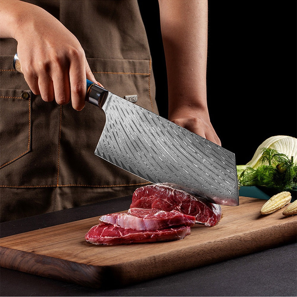 Hands slicing raw beef on a wooden board with a Damascus pattern Chinese cleaver with a blue resin handle