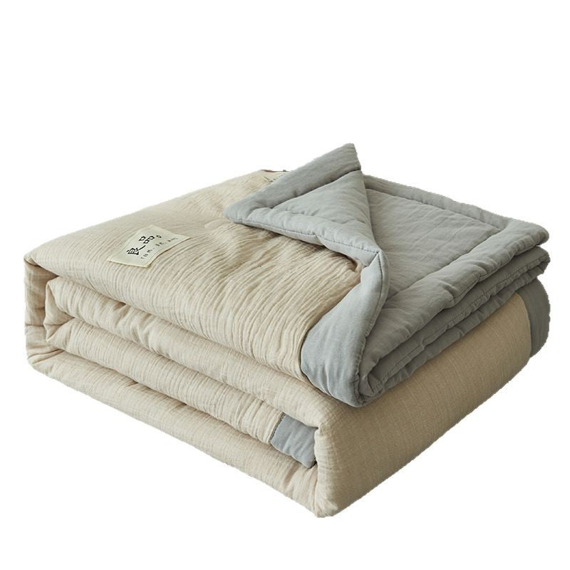Washed double gauze summer quilt draped over a bed showing crinkle crepe texture