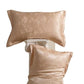 Pair of peach floral jacquard silk pillowcases, one flat and one on a column, on a white background