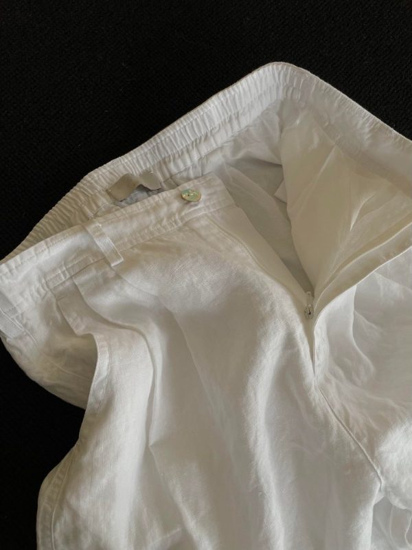 Inside waistband of white linen shorts with belt loop, zip fly and clean lining