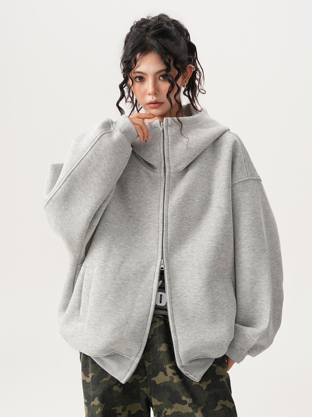 Deep hood of the heavyweight sweatshirt pulled up over the head and framing the face