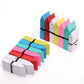Bundles of colored plastic plant label cards tied with black twine, some upright with a small hole near the top end