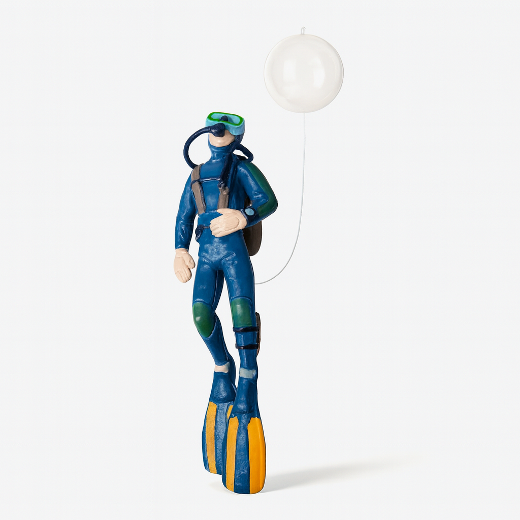 Aquarium diver ornament resting on gravel inside a planted fish tank