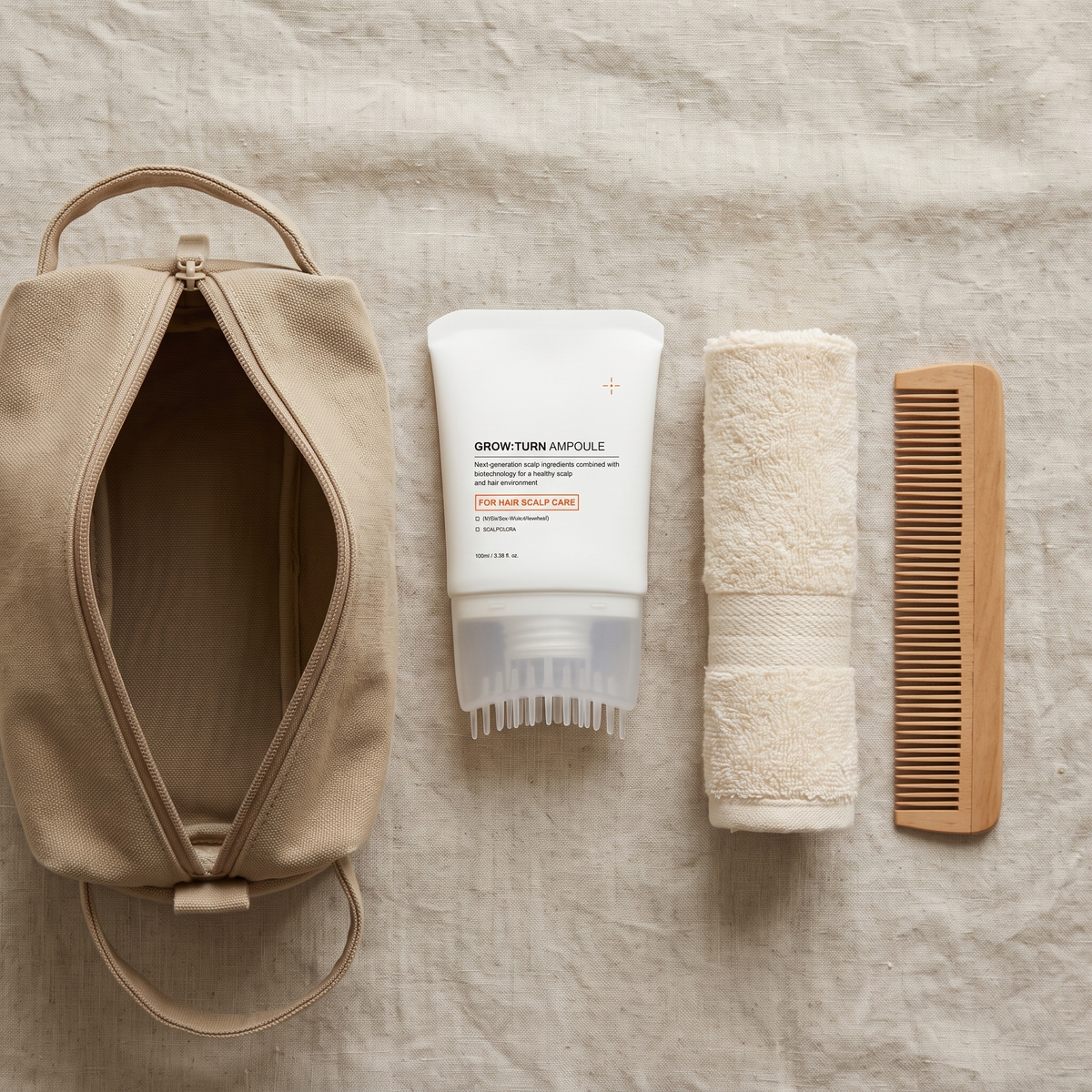 Scalp care hair essence in a travel flat lay with a wash bag