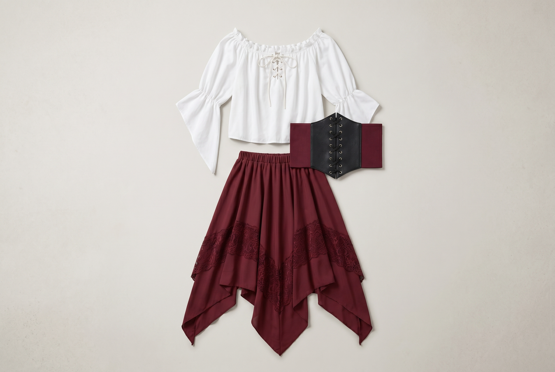Three piece Renaissance set flat lay in wine red, white peasant blouse, lace up corset and asymmetrical pointed hem skirt with lace trim