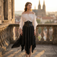 Woman wearing the Renaissance patchwork set on a stone castle terrace at golden hour