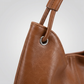 Close up of the walnut leather grain and the strap threaded through the silver eyelet