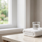 Clean bathroom vanity with towel and glass of water before adding the daily supplement