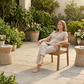Woman sitting on a plain stiff chair on the same terrace with no lounger to recline on