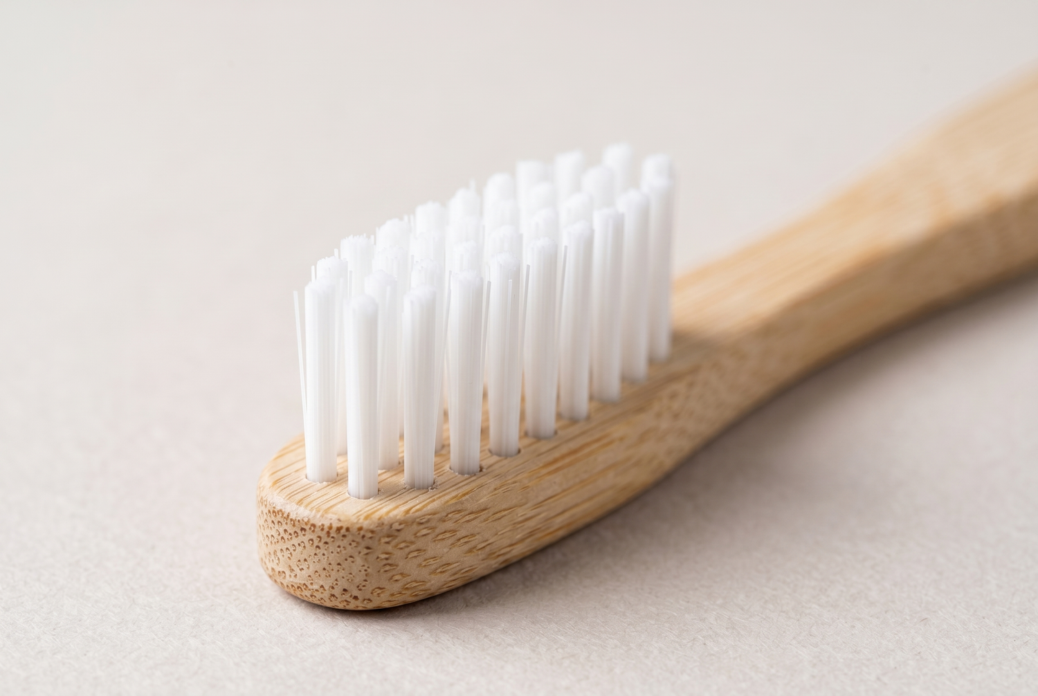 Close up of soft nylon rounded bristles set into a natural bamboo handle