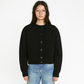 Side angle of the cropped knit cardigan showing the waist-length hem