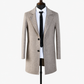 Side profile of the herringbone wool overcoat showing the knee-length skirt and sleeve