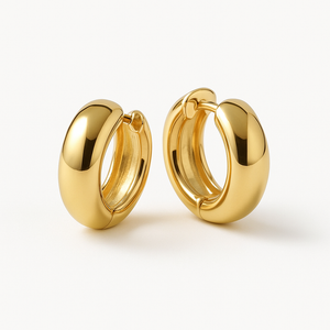 Front view of solid gold hoops held against pale linen