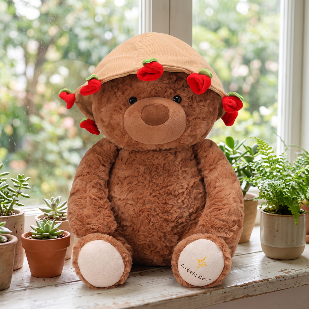 Brown plush rose bear wearing its rose corduroy hat on a sunny windowsill with plants