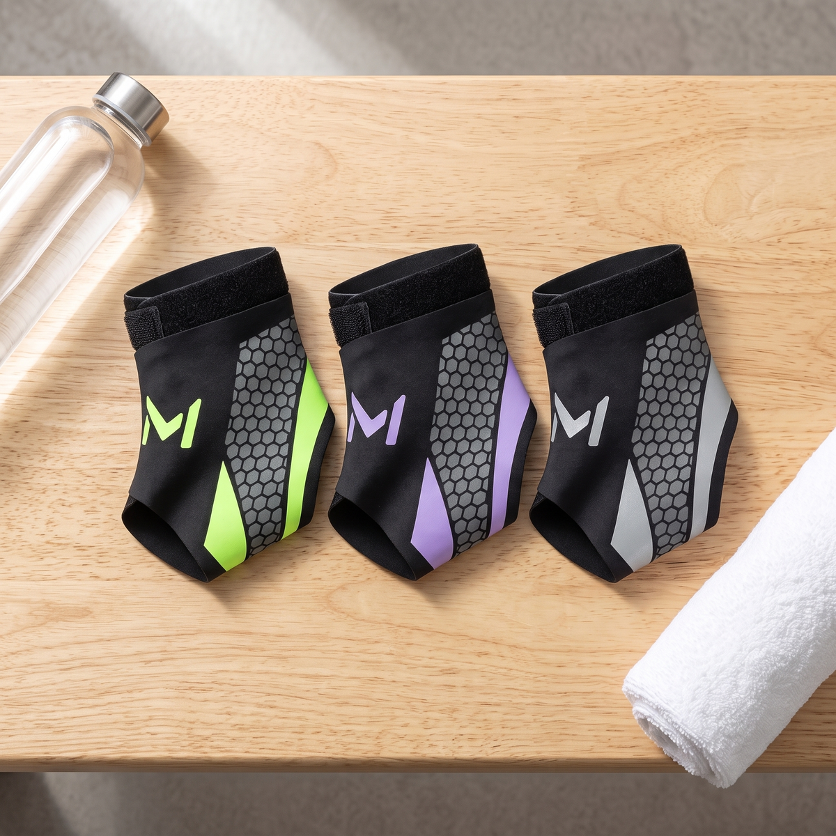 The ankle brace in green, purple and silver trim laid side by side on wood