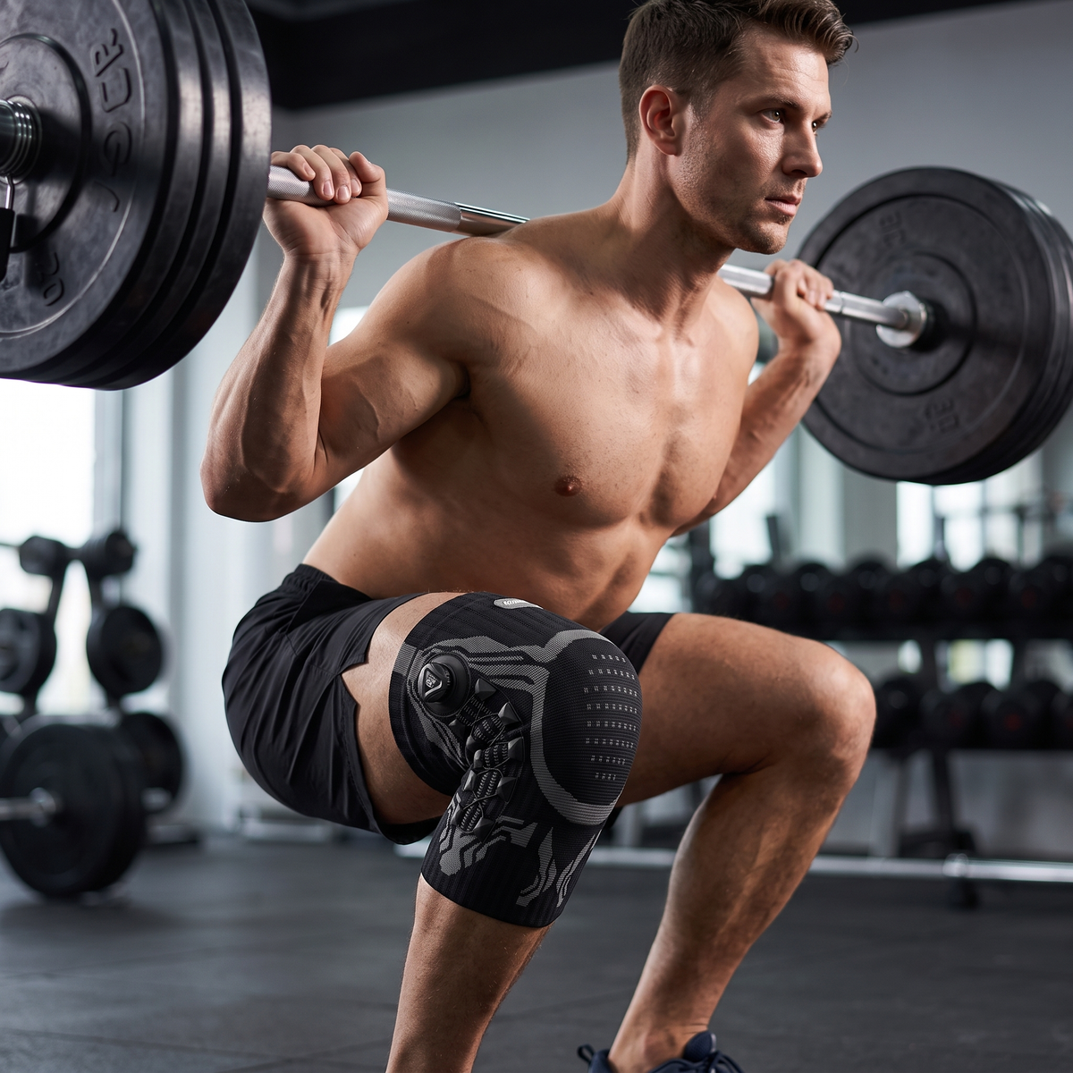 Athlete squatting with a barbell wearing the black KUANGMI knee brace