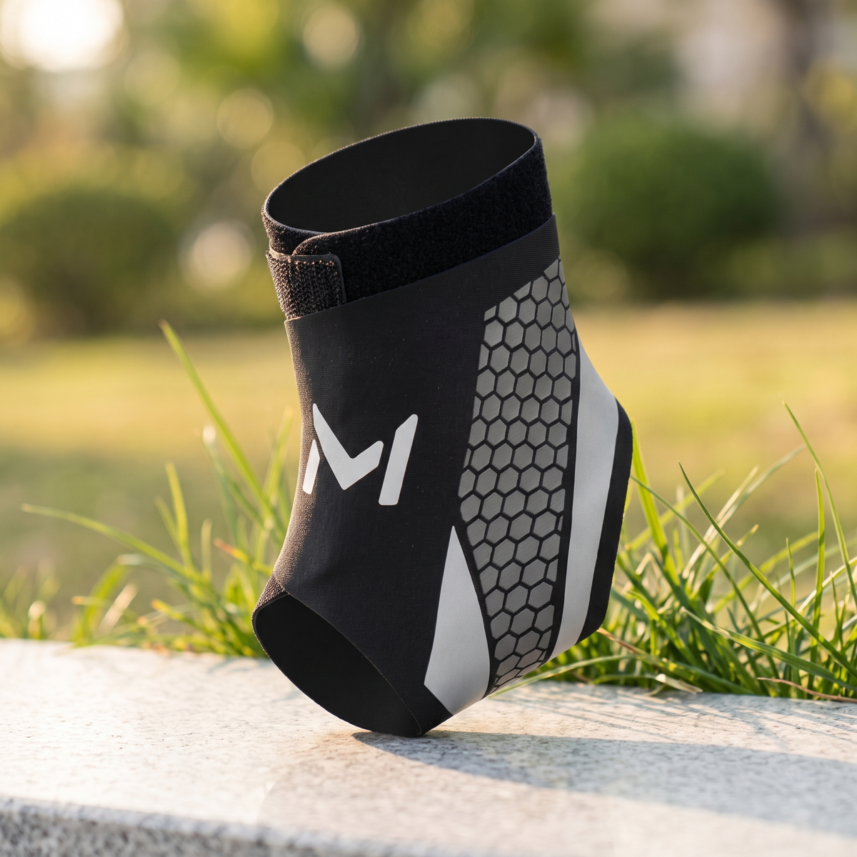 Silver trim ankle brace standing on a stone ledge with grass behind
