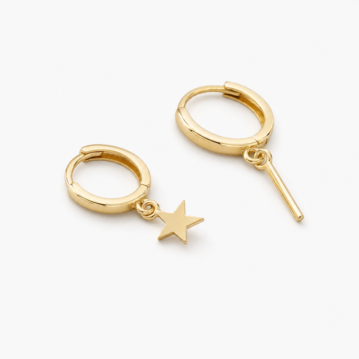 Plain hoop drop earrings laid on a small black velvet pouch on a wooden tray
