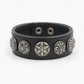 Black leather concho cuff bracelet worn on the wrist as a statement piece