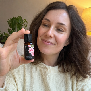 Customer review photo holding the rose essential oil bottle at home